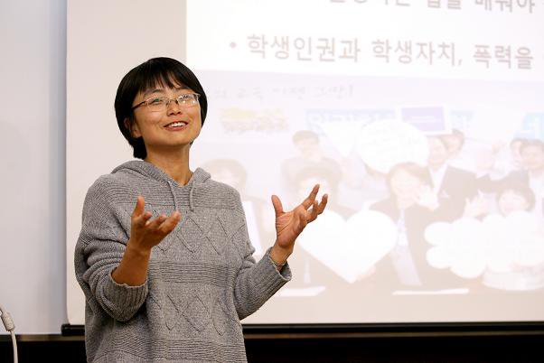 배경내 활동가가 스크린 앞에서 양손을 들고 교육을 진행하고 있다.